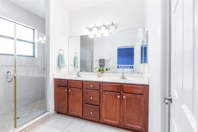 a bathroom with a granite countertop sink a mirror and a shower