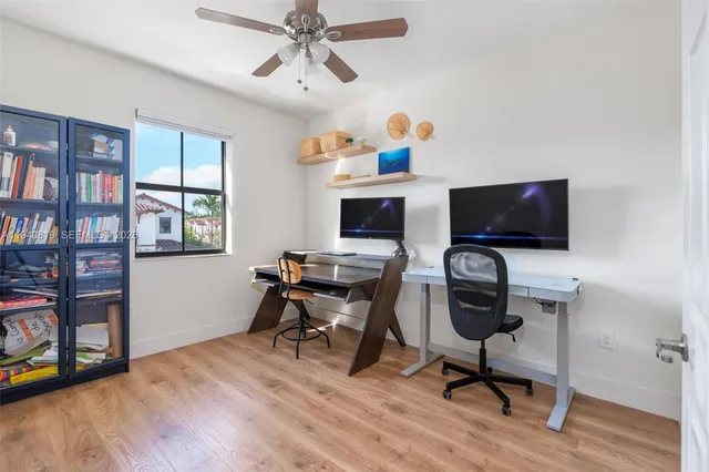 a view of a workspace with furniture and a window