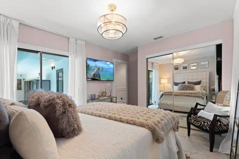 a bedroom with a bed mirror and window