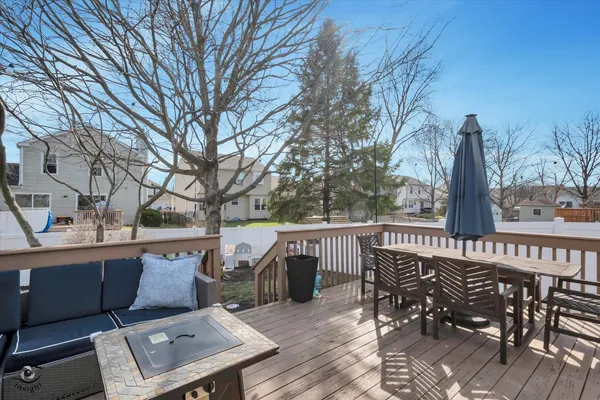 a view of a roof deck with table and chairs and wooden floor