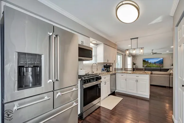 a kitchen with granite countertop stainless steel appliances and wooden floor