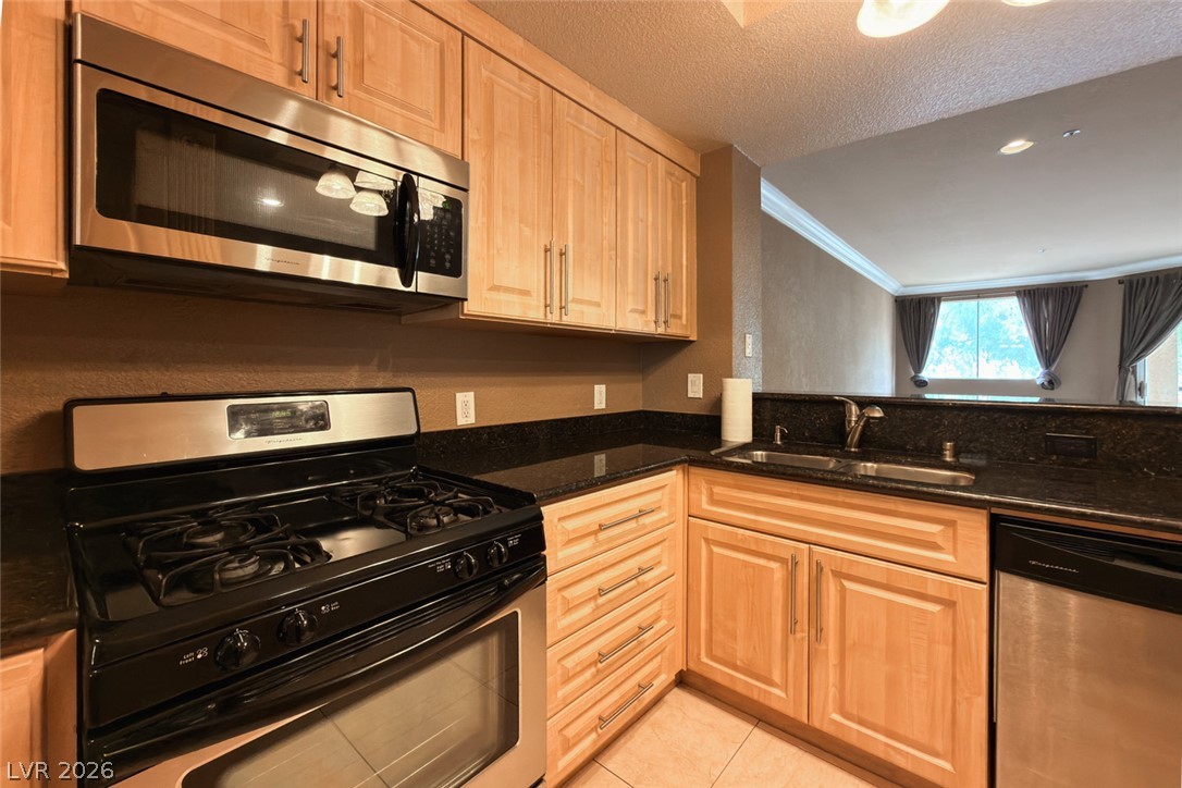 210 East Flamingo Road, Unit 112 Las Vegas, NV 89169 - Photo 9 of 59 Gleaming stone countertops and warm wood cabinetry define this functional, open culinary workspace.