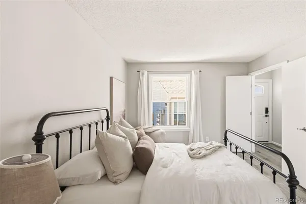 a bedroom with a bed a couch and windows