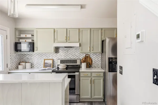 a kitchen with stainless steel appliances a sink stove refrigerator and cabinets