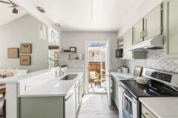 a kitchen with stainless steel appliances a sink stove and cabinets