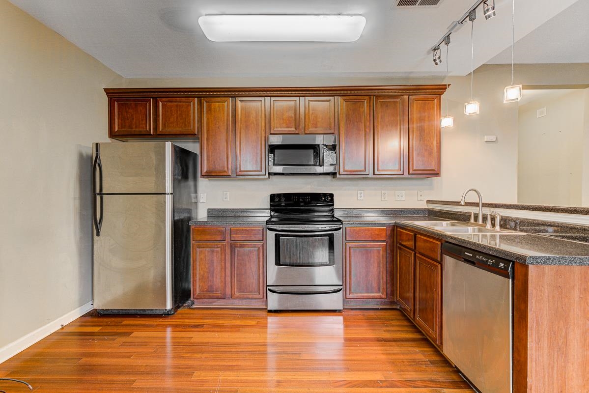731 Litty Court, Unit 105 Memphis, TN 38103 - Photo 8 of 15 a kitchen with granite countertop a refrigerator and a stove top oven