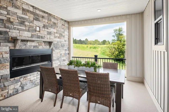 a dining room with furniture a fireplace and wooden floor