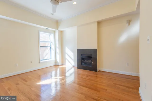 a view of empty room with wooden floor and fireplace