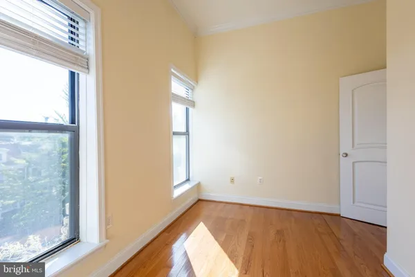 a view of an empty room and wooden floor and a window