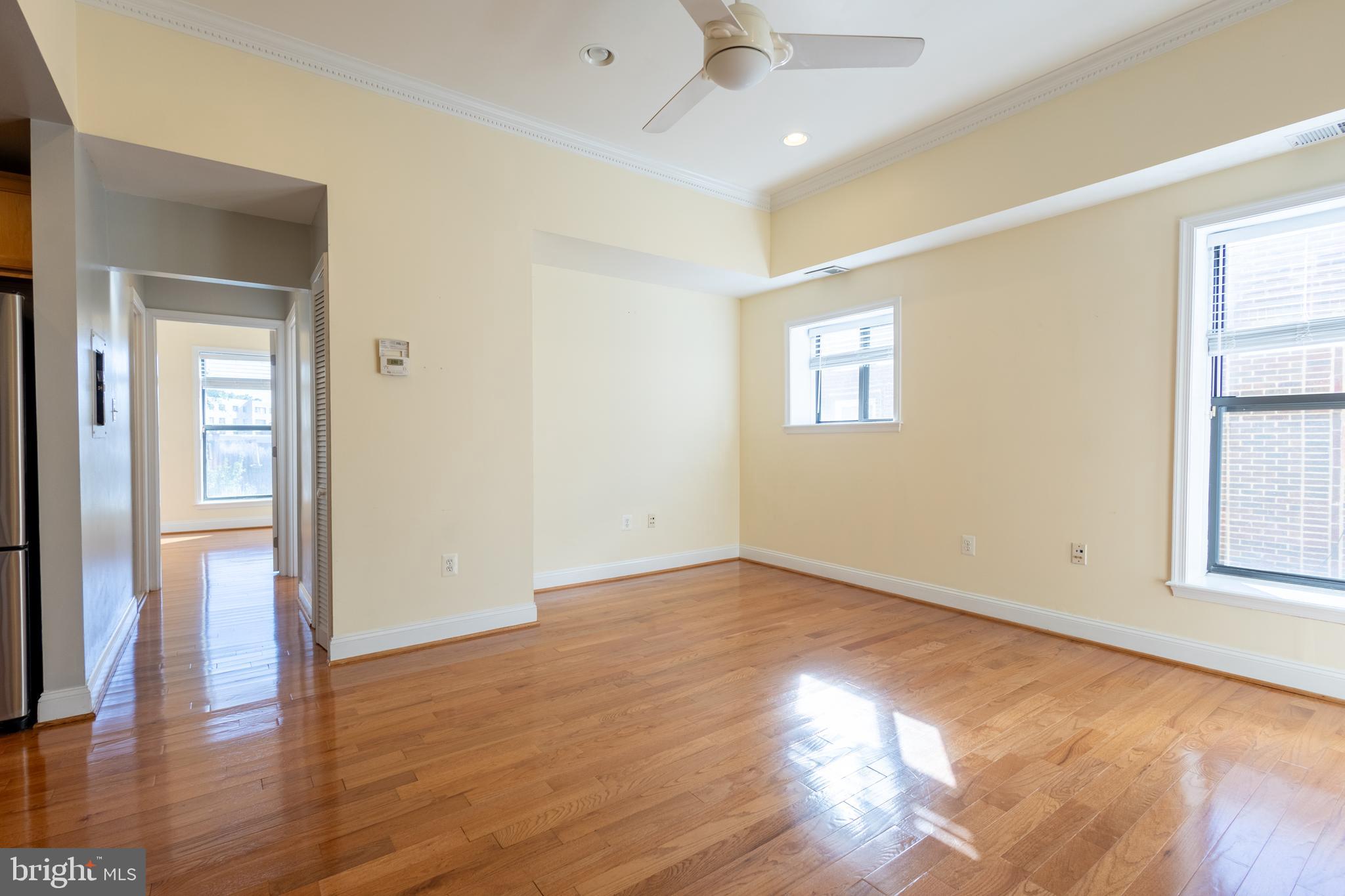 1437 Spring Road Northwest, Unit 32 Washington, DC 20010 - Photo 8 of 13 an empty room with wooden floor and windows