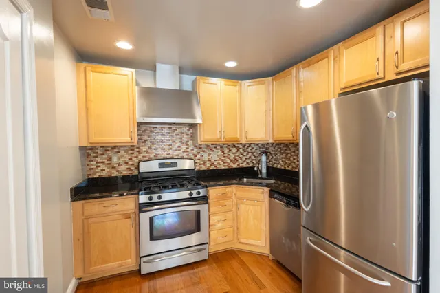 a kitchen with granite countertop a refrigerator stove and microwave