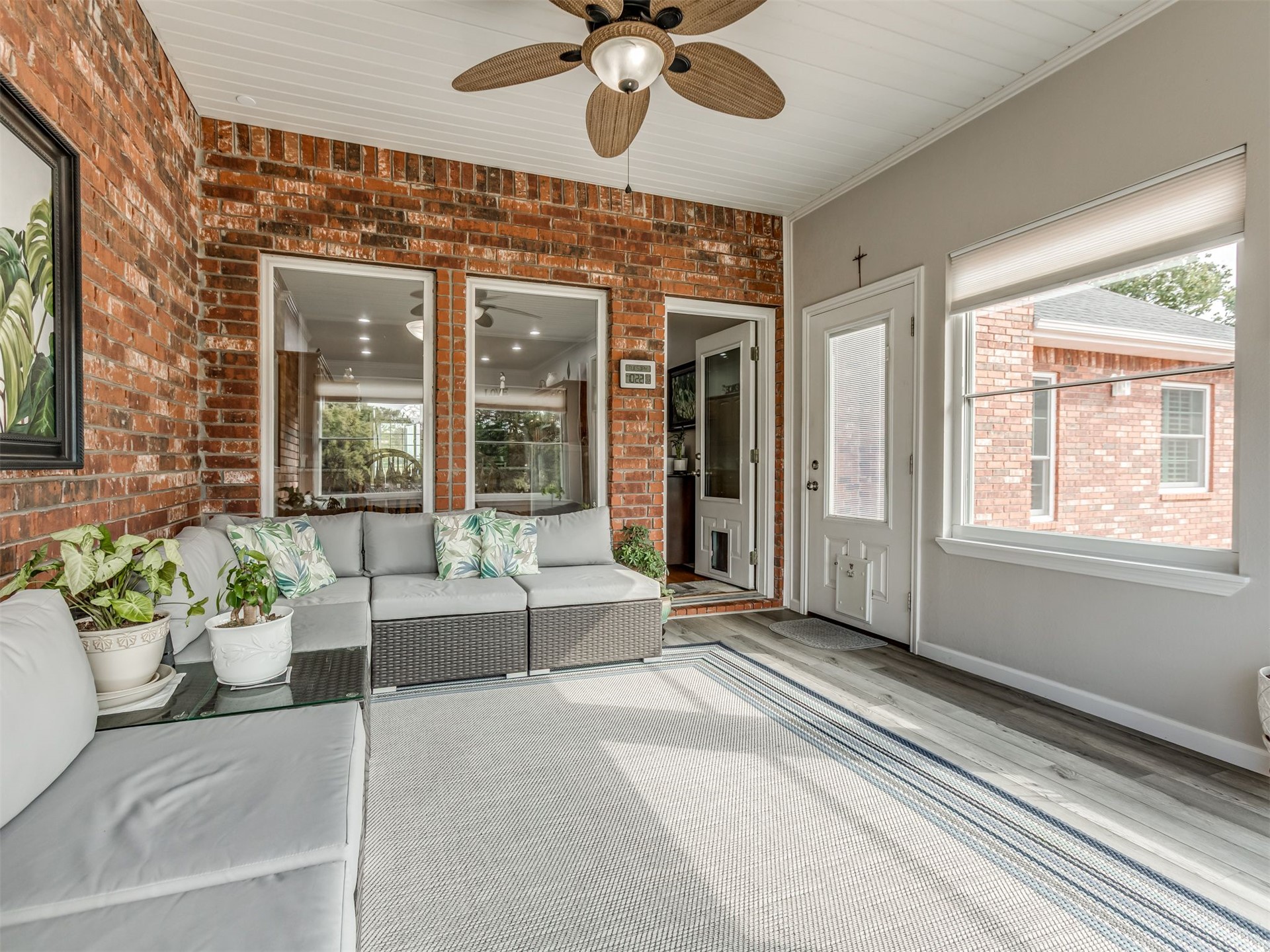 119 Mainsail Road Stigler, OK 74462 - Photo 36 of 52 Enclosed patio with exposed brick wall, wood-finish flooring, white paneled ceiling, and a ceiling fan