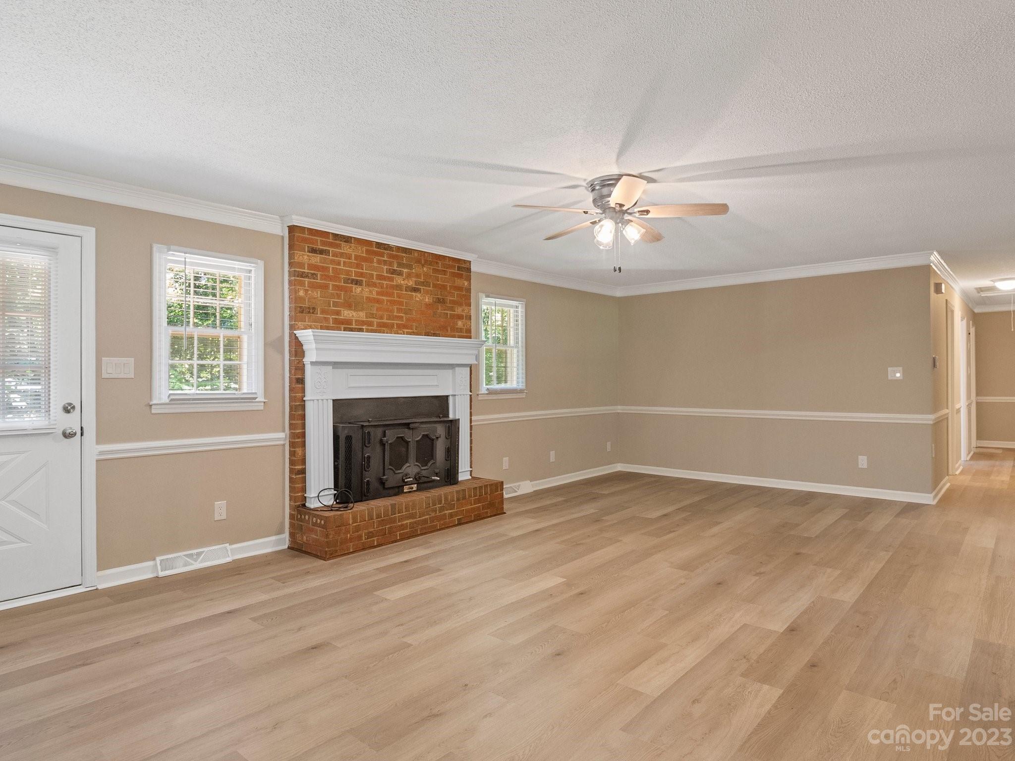 807 Red Cedar Lane Monroe, NC 28110 - Photo 12 of 34 wooden floor fireplace and windows in an empty room
