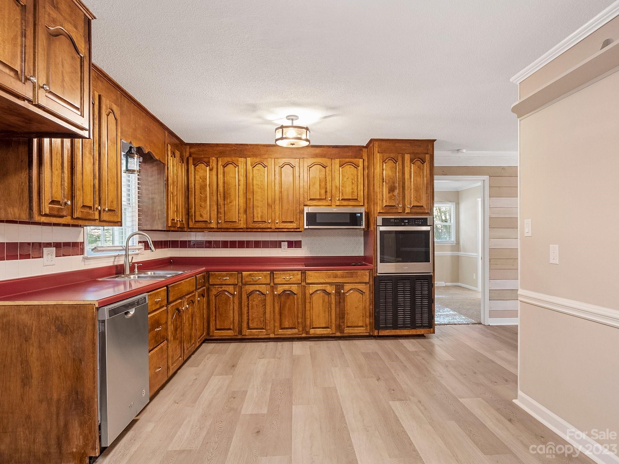 807 Red Cedar Lane Monroe, NC 28110 - Photo 16 of 34 a kitchen with stainless steel appliances granite countertop a sink and wooden cabinets