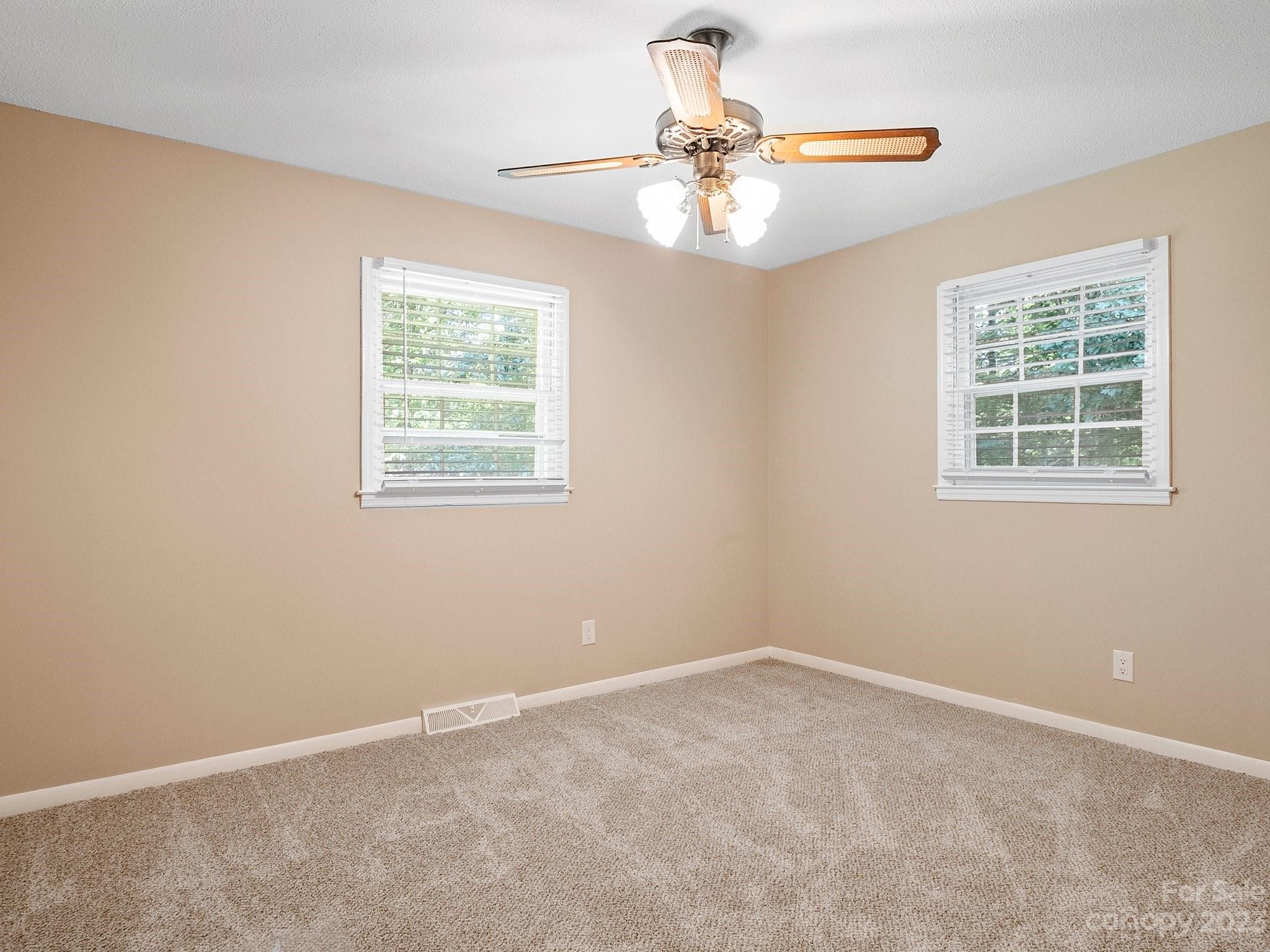 807 Red Cedar Lane Monroe, NC 28110 - Photo 22 of 34 an empty room with a chandelier fan and windows
