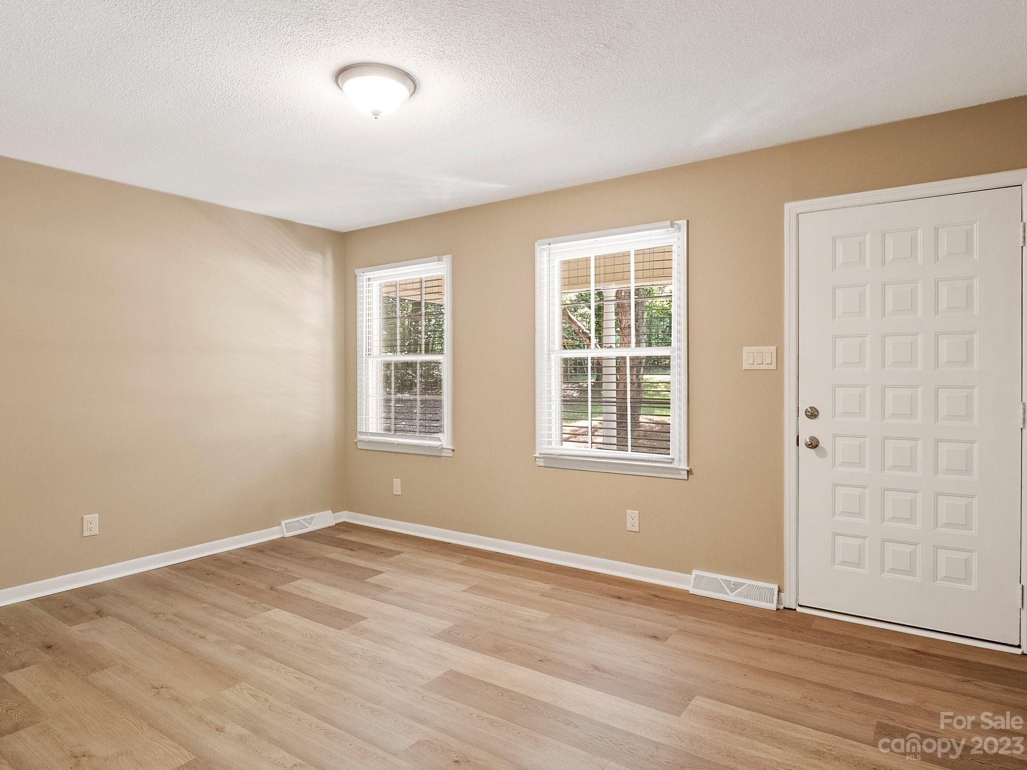 807 Red Cedar Lane Monroe, NC 28110 - Photo 8 of 34 a view of an empty room with wooden floor and a window