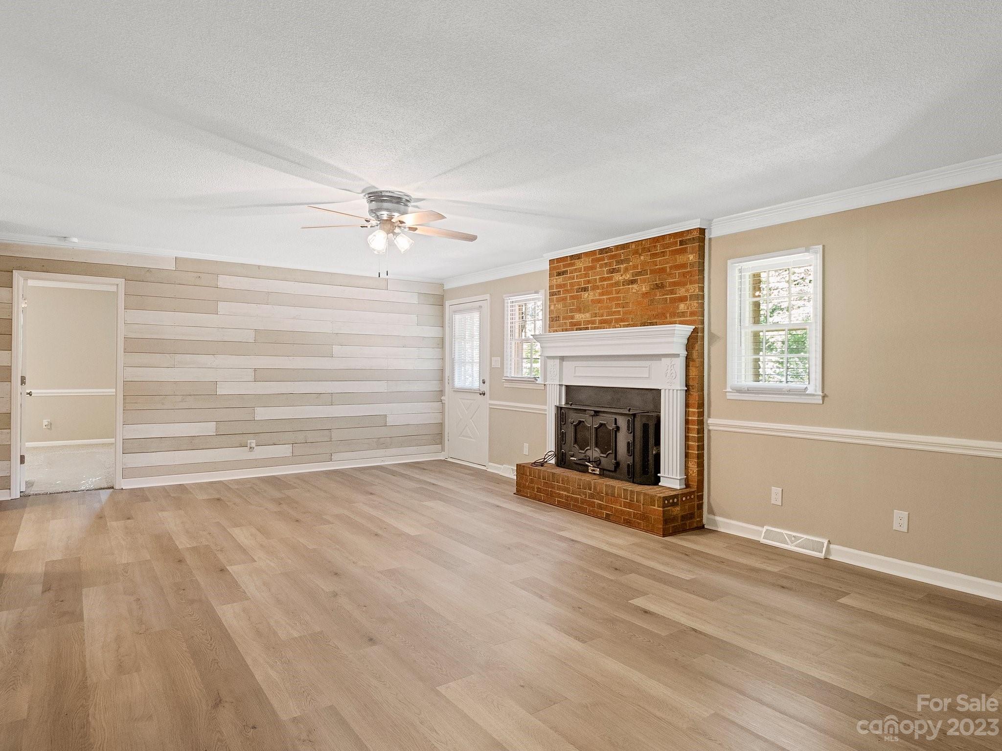 807 Red Cedar Lane Monroe, NC 28110 - Photo 10 of 34 a view of a livingroom with a fireplace a ceiling fan and windows