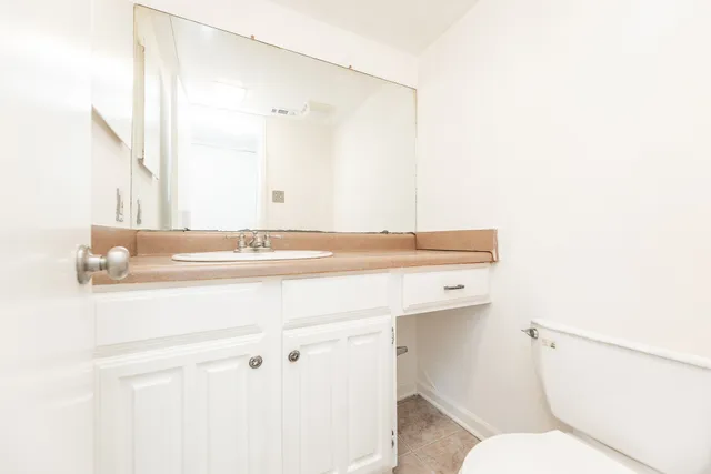 a bathroom with a sink a toilet and mirror
