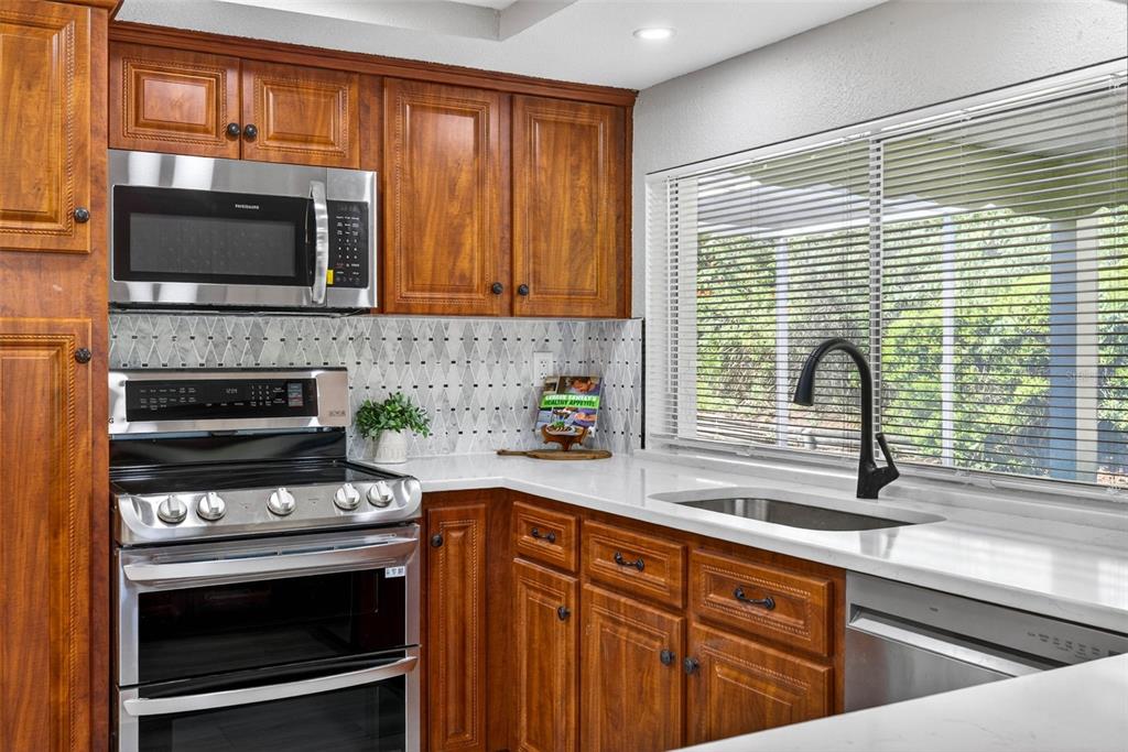 12415 Stagecoach Lane Hudson, FL 34667 - Photo 13 of 51 a kitchen with a stove a sink and a microwave
