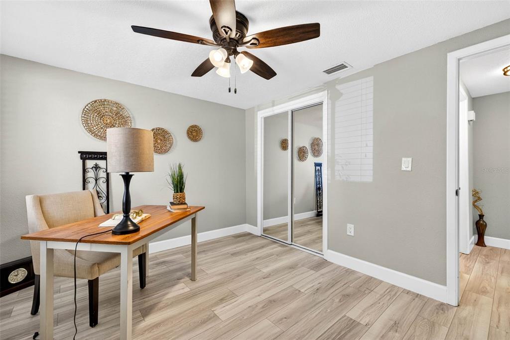 12415 Stagecoach Lane Hudson, FL 34667 - Photo 23 of 51 a view of a workspace with furniture and wooden floor
