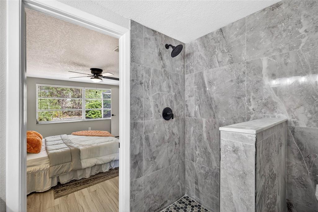 12415 Stagecoach Lane Hudson, FL 34667 - Photo 32 of 51 a bedroom with a bed and a window with glass doors