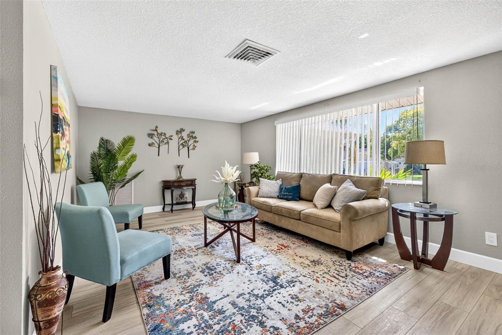 12415 Stagecoach Lane Hudson, FL 34667 - Photo 5 of 51 a living room with furniture and a wooden floor