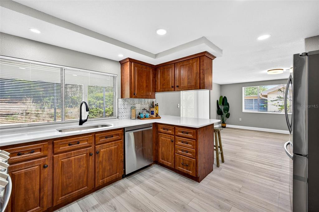 12415 Stagecoach Lane Hudson, FL 34667 - Photo 9 of 51 a kitchen with stainless steel appliances granite countertop wooden floors and sink