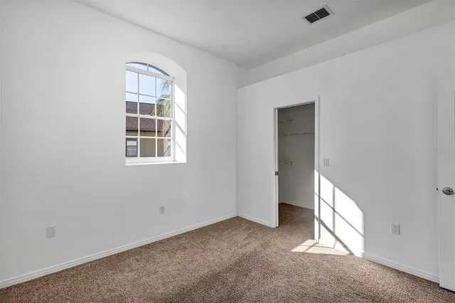 a large bedroom with a bed and a mirror