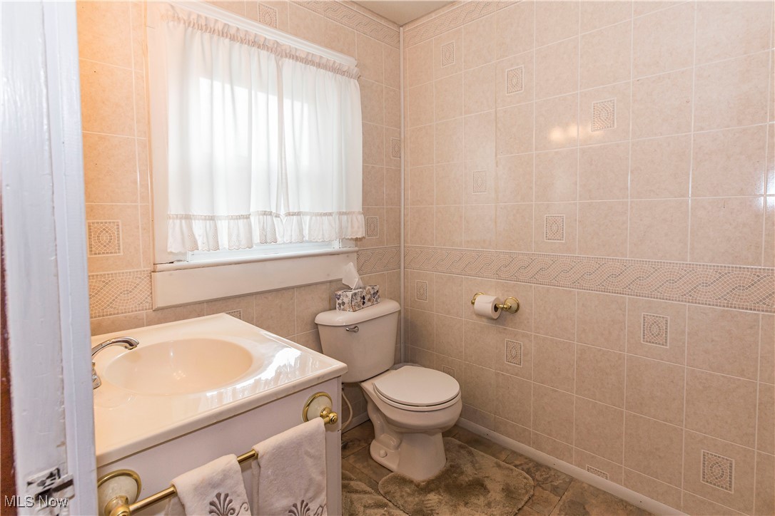 749 Amherst Road Northeast Massillon, OH 44646 - Photo 20 of 41 Bathroom featuring vanity and tile walls