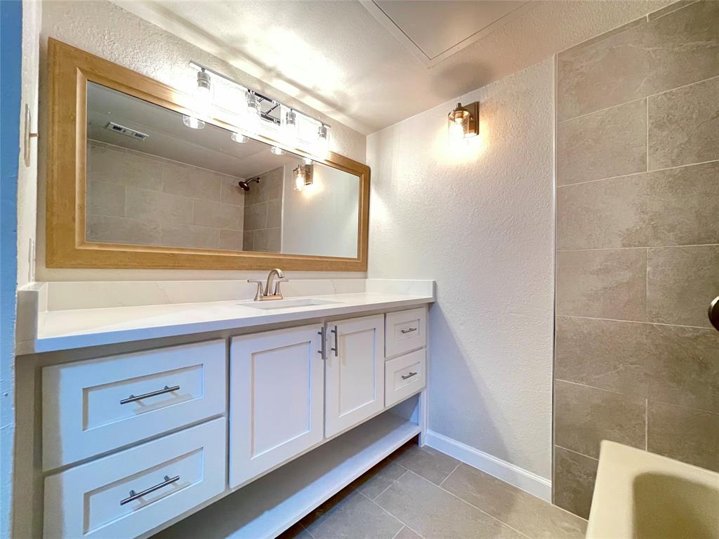 336 Melrose Drive, Unit 5C Richardson, TX 75080 - Photo 15 of 22 a spacious bathroom with a double vanity sink a mirror and a shower