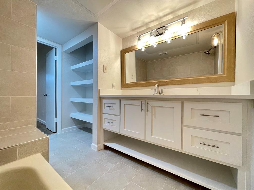 336 Melrose Drive, Unit 5C Richardson, TX 75080 - Photo 16 of 22 a bathroom with a sink and a mirror