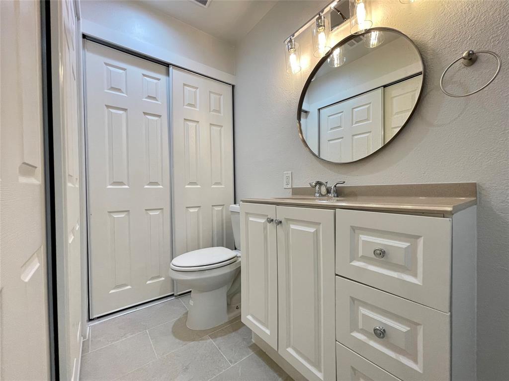 336 Melrose Drive, Unit 5C Richardson, TX 75080 - Photo 19 of 22 a bathroom with a toilet a sink and a mirror