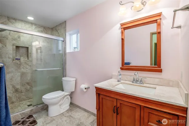 a bathroom with a sink a toilet and shower