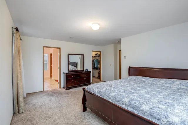 a bedroom with a large bed and dresser