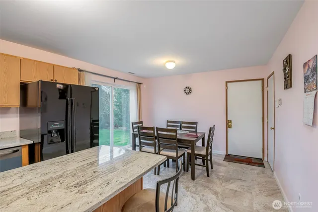 a kitchen with stainless steel appliances kitchen island granite countertop a refrigerator and a stove top oven