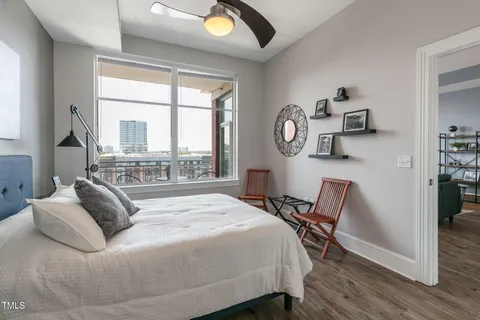 a bedroom with a bed chandelier and a window
