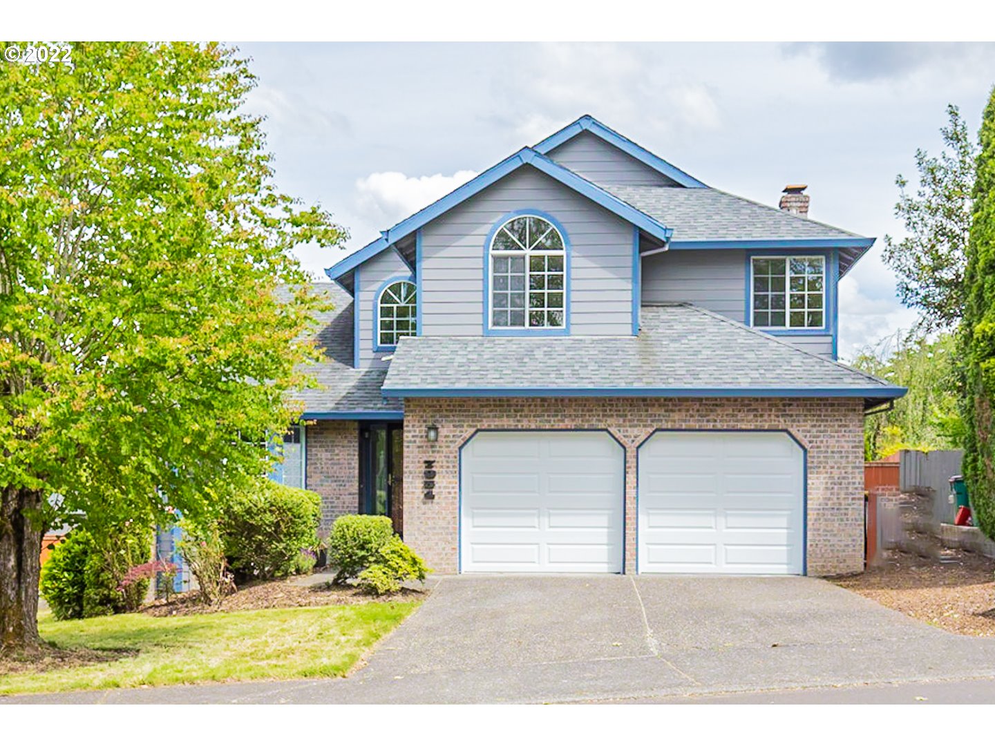 a front view of a house with a yard and garage