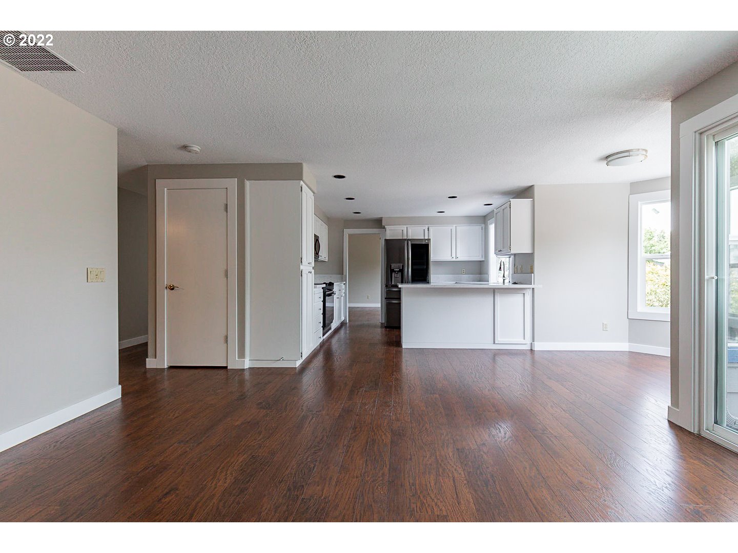 7354 Southwest 166th Terrace Beaverton, OR 97007 - Photo 10 of 32 a view of a big room with wooden floor and a kitchen
