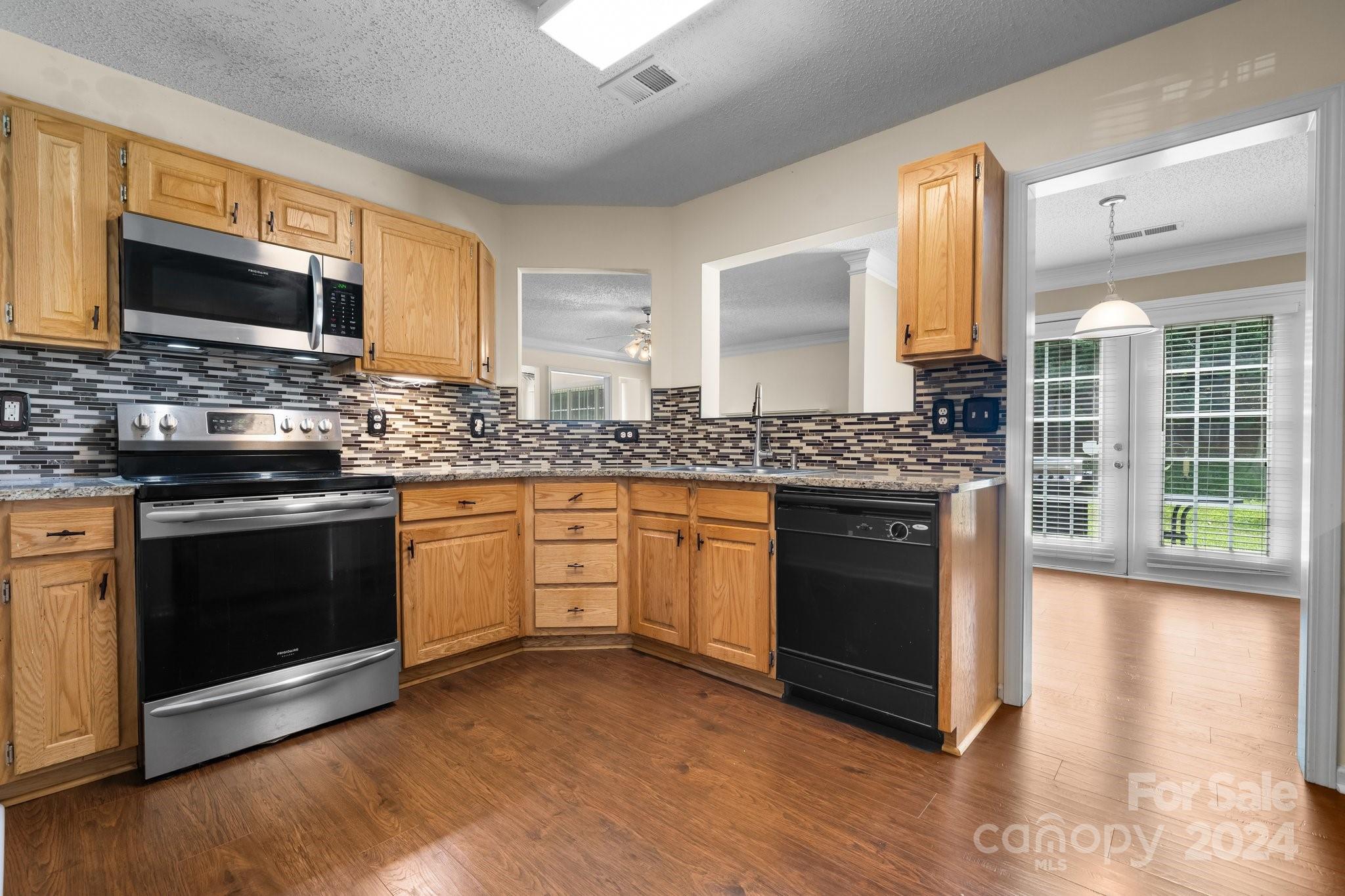 813 Raindrops Road Gastonia, NC 28054 - Photo 17 of 42 a kitchen with stainless steel appliances granite countertop wooden cabinets stove top oven and sink