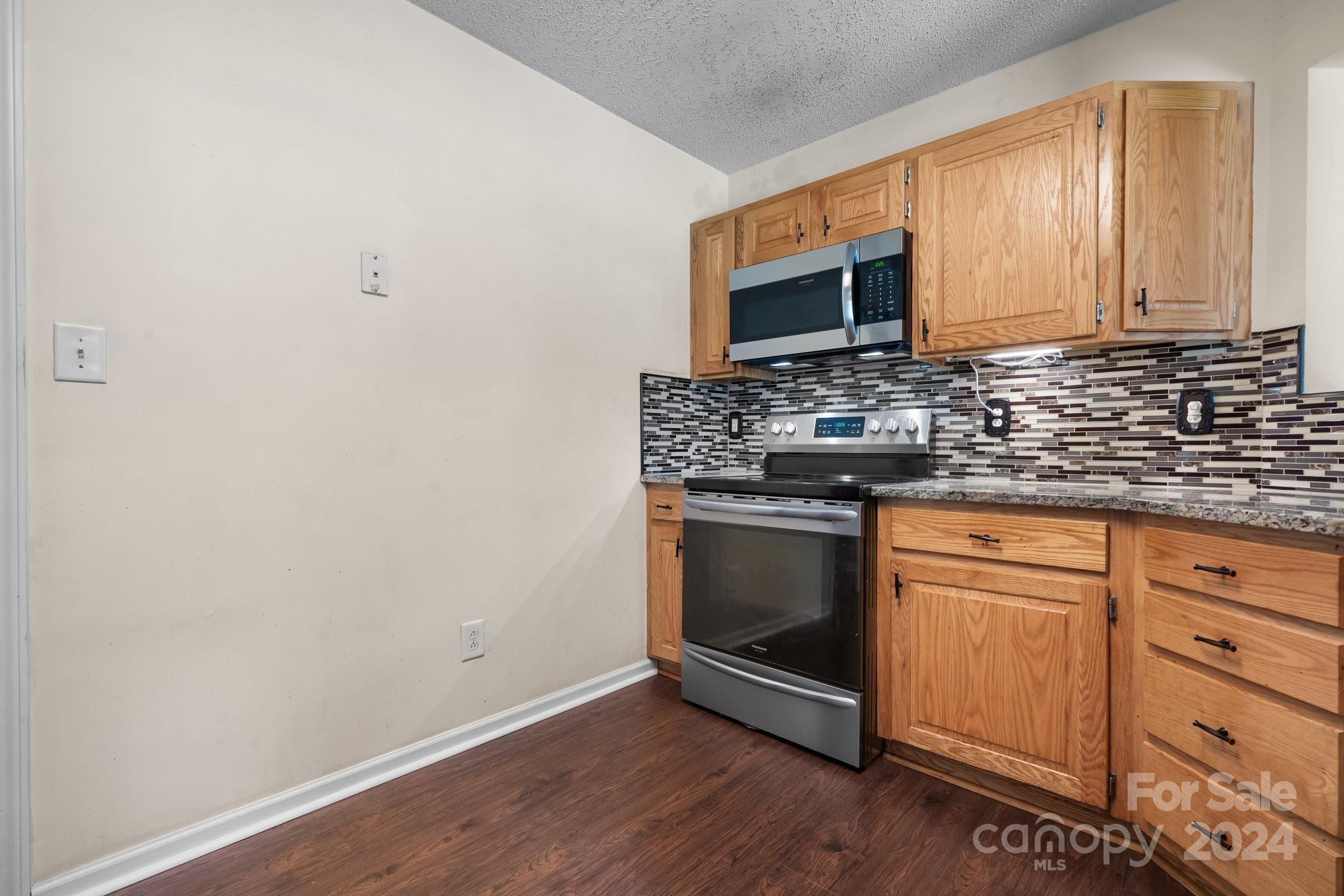 813 Raindrops Road Gastonia, NC 28054 - Photo 18 of 42 a kitchen with granite countertop a stove microwave and sink