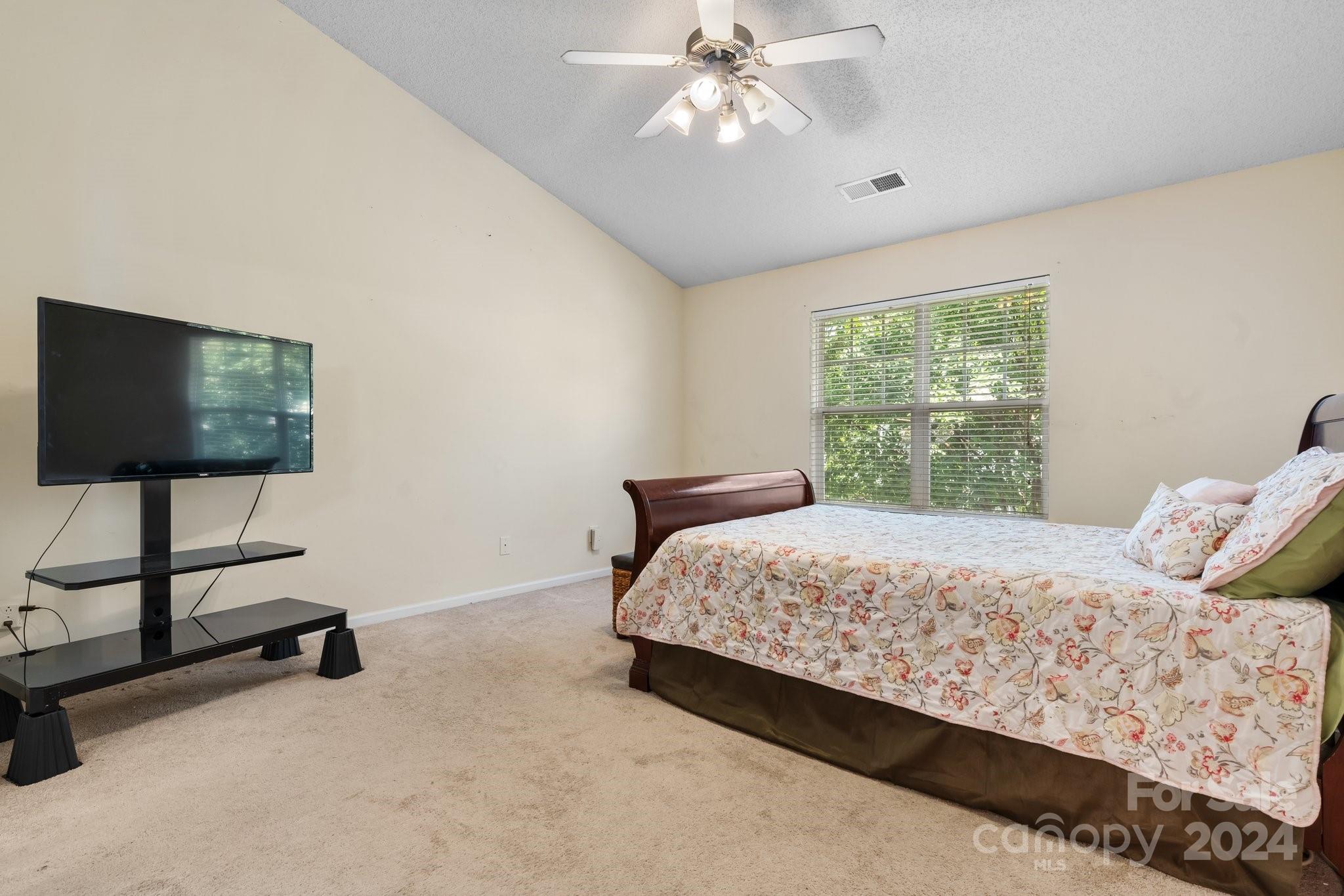 813 Raindrops Road Gastonia, NC 28054 - Photo 26 of 42 a bedroom with a bed and a flat screen tv