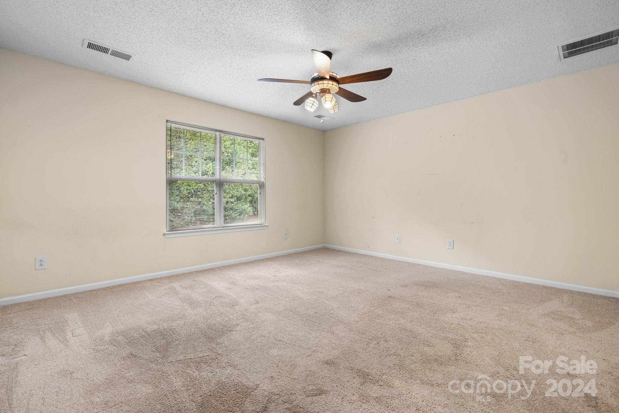 813 Raindrops Road Gastonia, NC 28054 - Photo 31 of 42 an empty room with a window and a ceiling fan