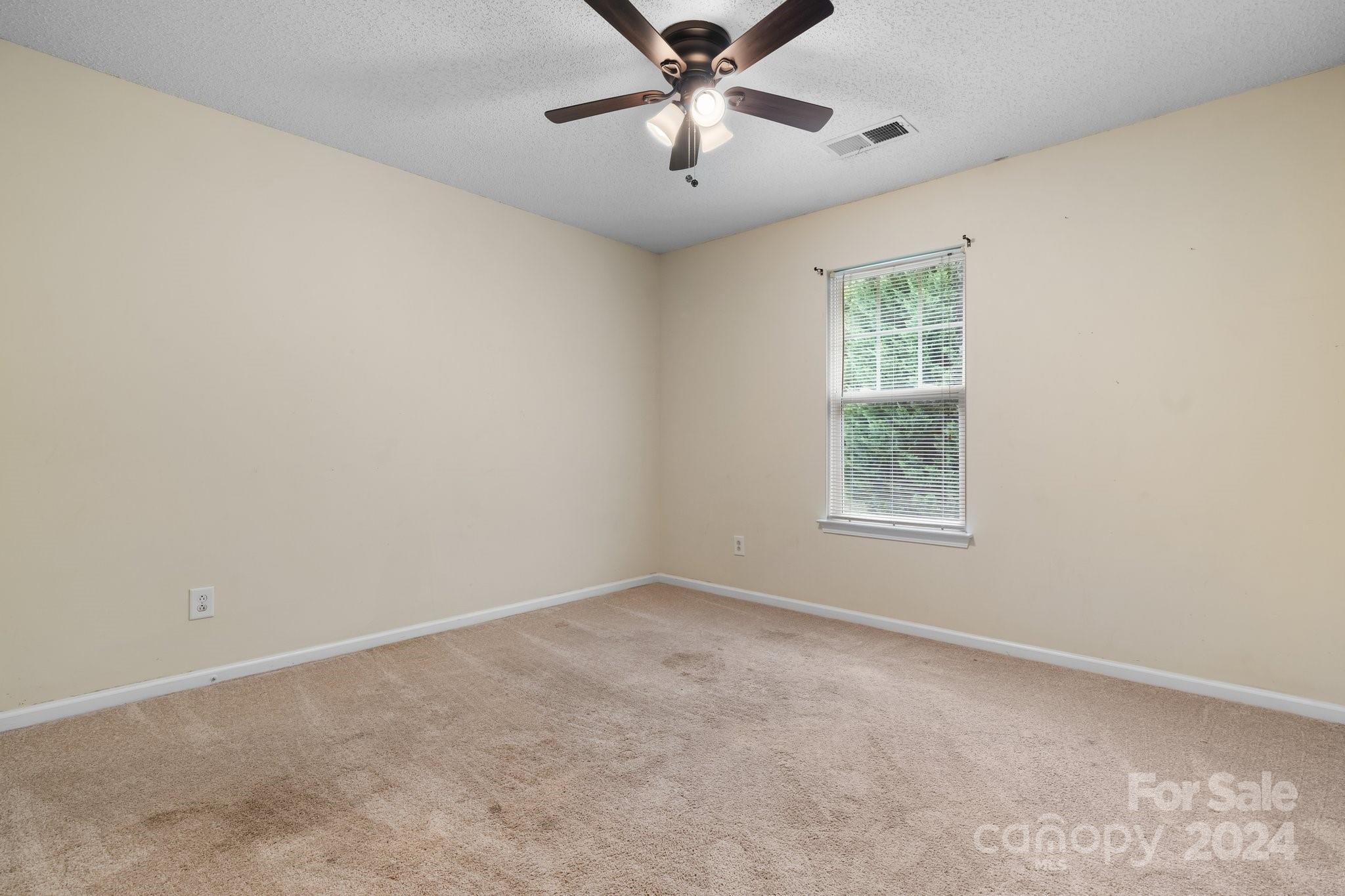 813 Raindrops Road Gastonia, NC 28054 - Photo 32 of 42 an empty room with a window and a fan