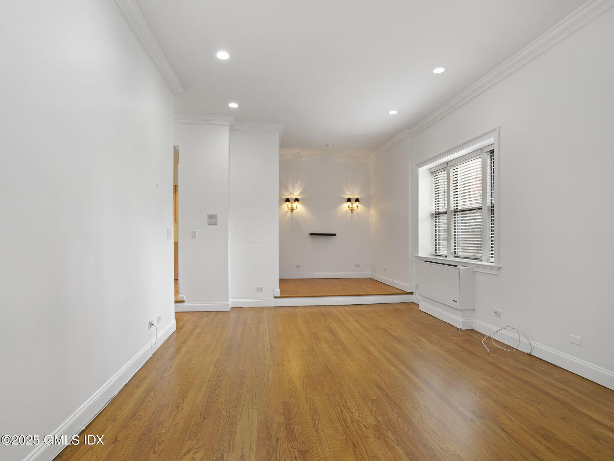 40 West Elm Street, Unit 1M Greenwich, CT 06830 - Photo 7 of 16 a view of an empty room with wooden floor and a window