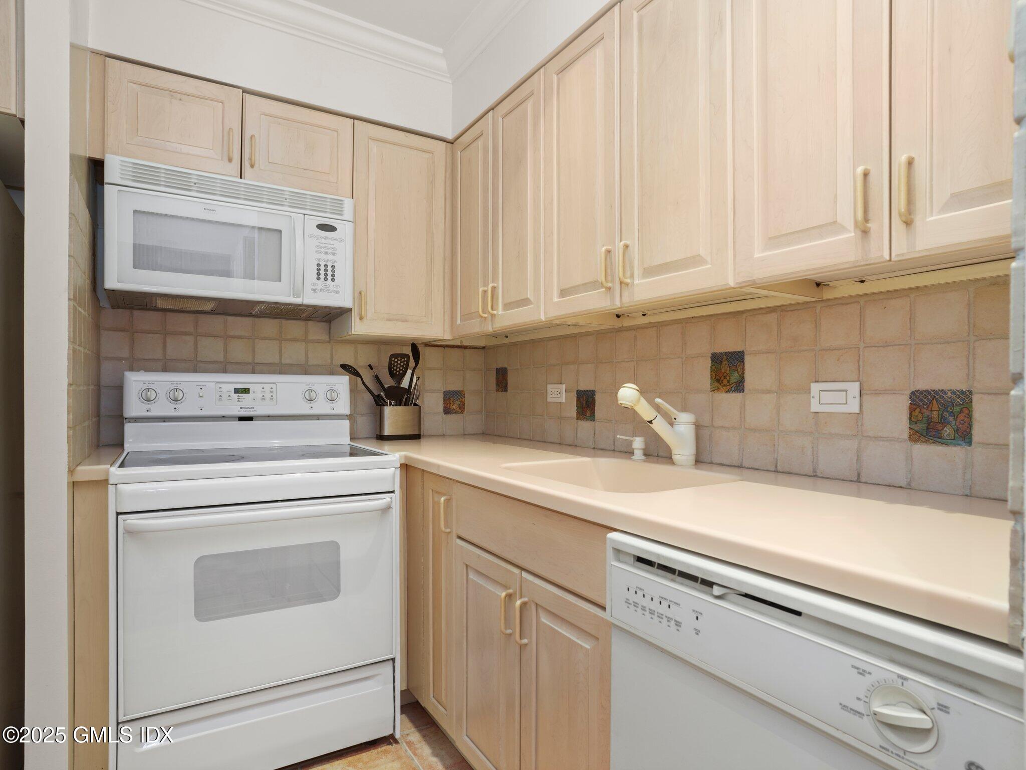 40 West Elm Street, Unit 1M Greenwich, CT 06830 - Photo 9 of 16 a kitchen with granite countertop white cabinets and white appliances