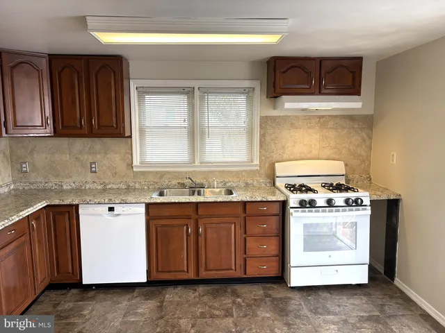 a kitchen with stainless steel appliances granite countertop a stove sink and cabinets