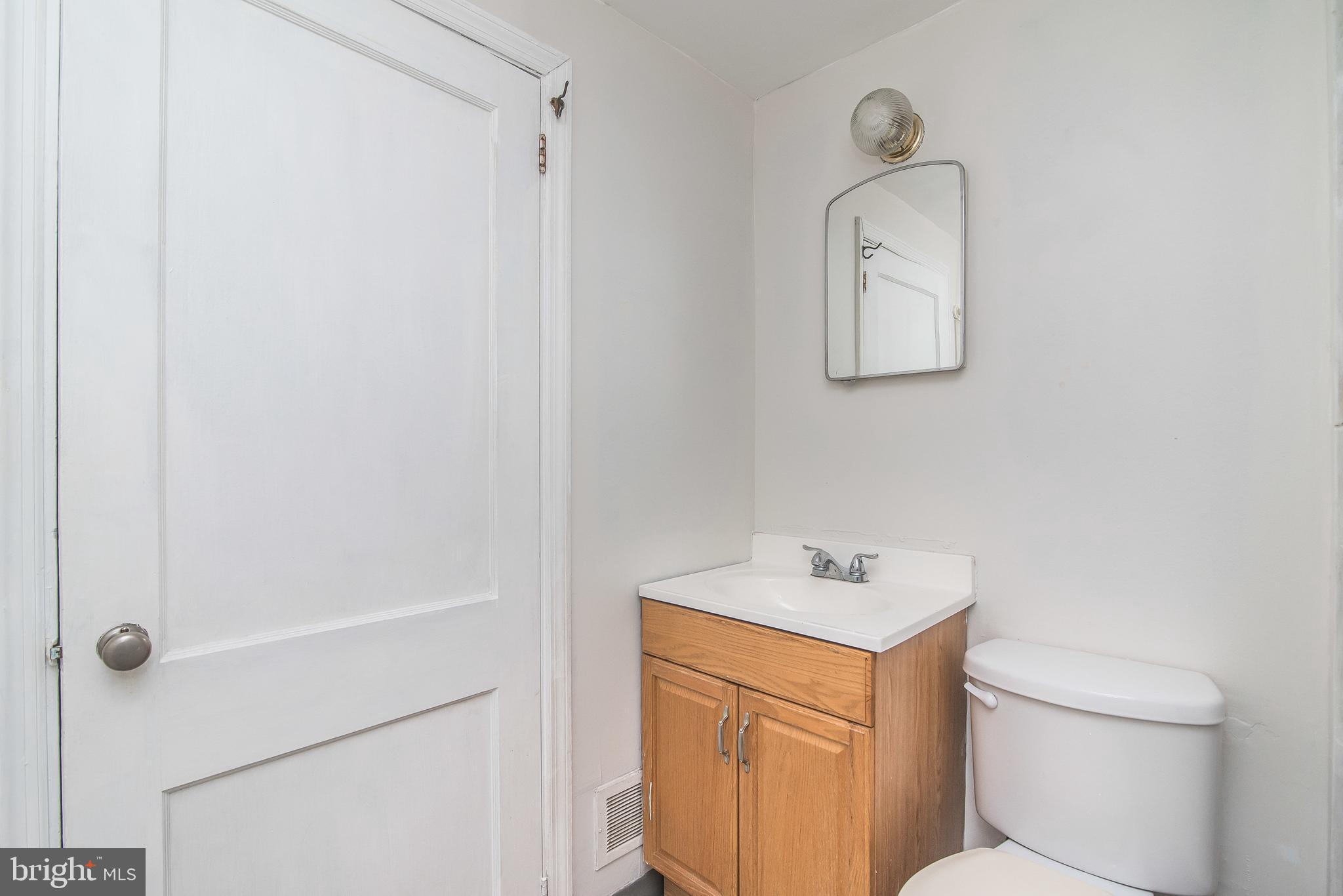 7717 Baltimore Annapolis Boulevard, Unit B Glen Burnie, MD 21060 - Photo 15 of 17 a bathroom with a sink a toilet and a mirror