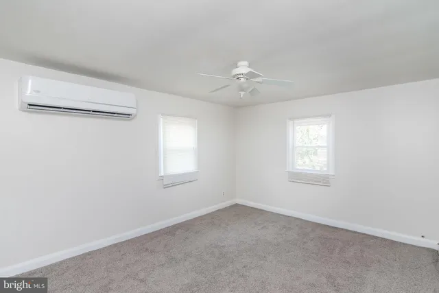 an empty room with a window and a ceiling fan