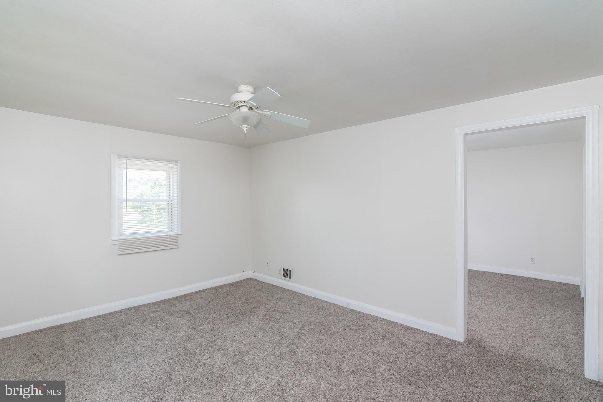 7717 Baltimore Annapolis Boulevard, Unit B Glen Burnie, MD 21060 - Photo 8 of 17 an empty room with a window and a ceiling fan
