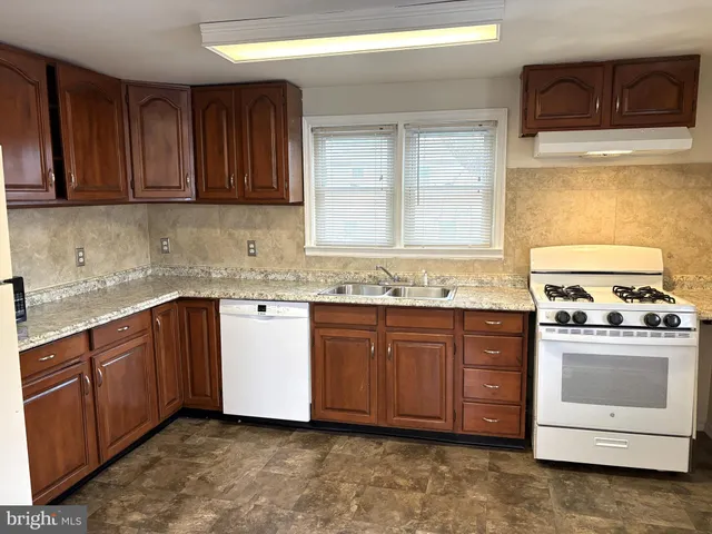 a kitchen with granite countertop a sink and a stove